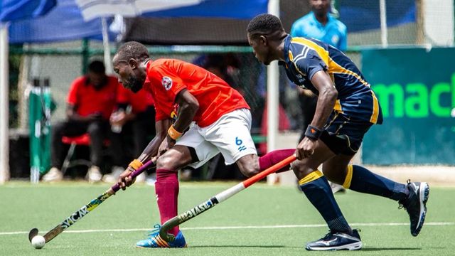 Allan Malit (left) of Kampala Hockey Club dribble past Linton Nayombe of USIU in their opening match at the ACCC